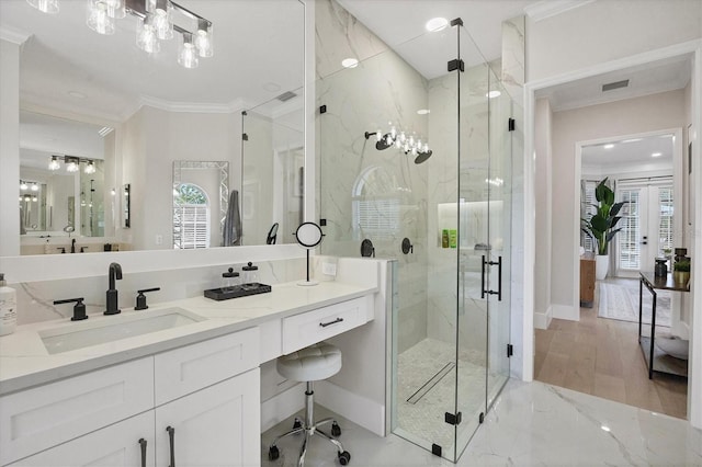 bathroom with a shower with door, vanity, ornamental molding, and wood-type flooring