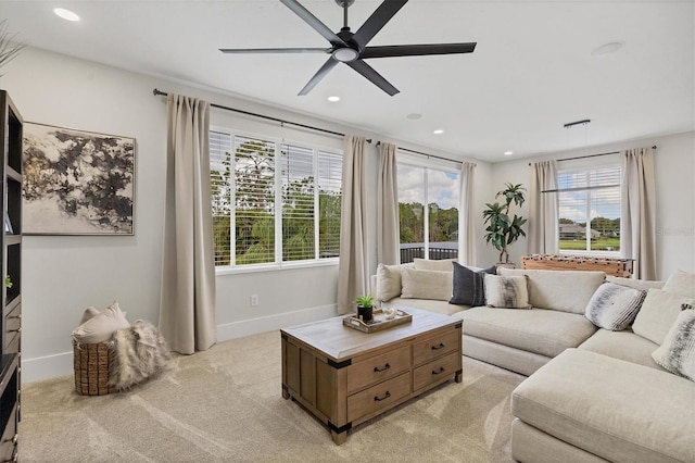 carpeted living room with ceiling fan