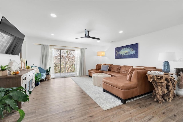 living room featuring light hardwood / wood-style flooring and ceiling fan