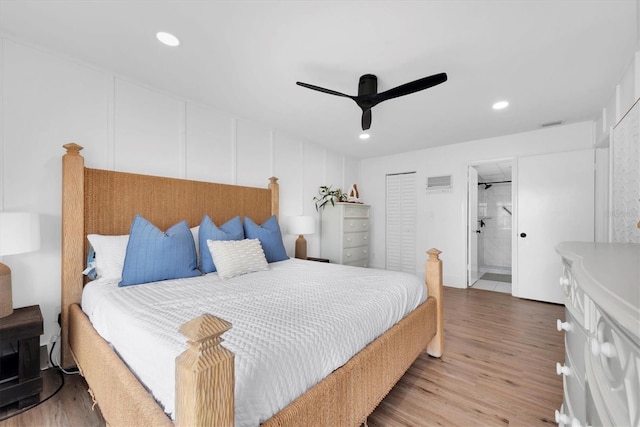 bedroom with hardwood / wood-style floors, ensuite bathroom, and ceiling fan