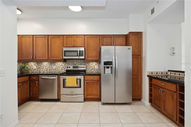 4260 Central Sarasota Pkwy Unit 213, Sarasota, FL 34238 - kitchen featuring appliances with stainless steel finishes, dark countertops, tasteful backsplash, and brown cabinetry