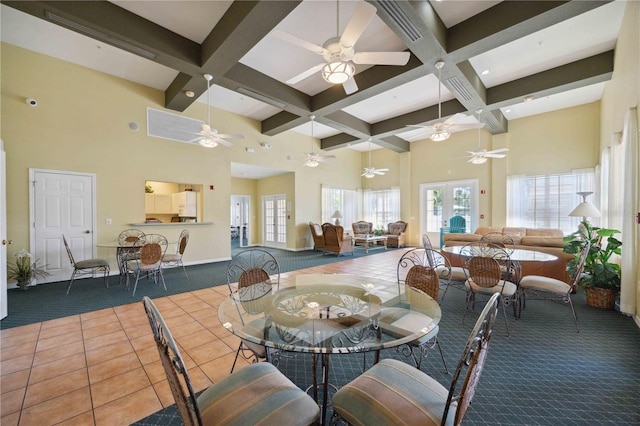 dining room with a towering ceiling, coffered ceiling, carpet, and beam ceiling