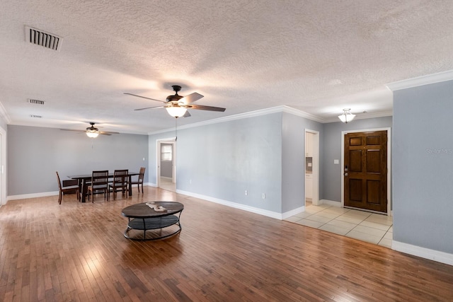 living room featuring light hardwood / wood-style floors, crown molding, a textured ceiling, and ceiling fan