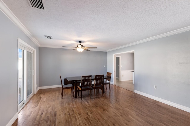 dining space with crown molding, a textured ceiling, dark hardwood / wood-style flooring, and ceiling fan