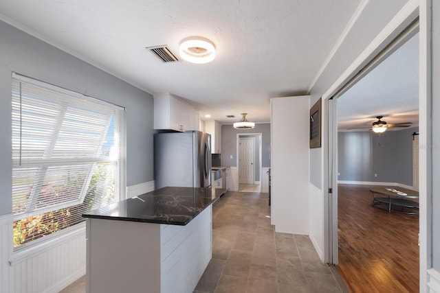 kitchen with ornamental molding, stainless steel fridge, light wood-type flooring, white cabinetry, and ceiling fan