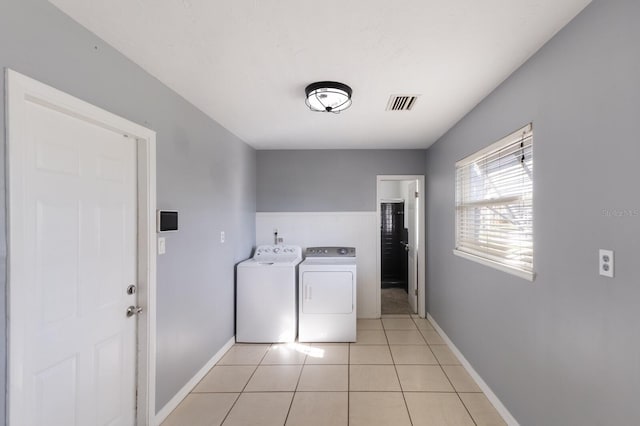 laundry room featuring independent washer and dryer and light tile patterned floors