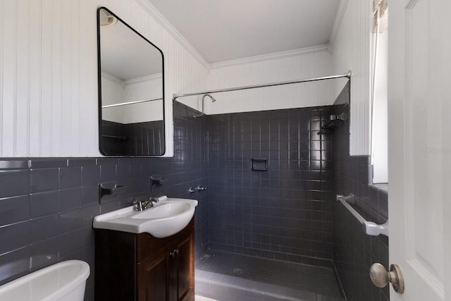 bathroom featuring vanity, crown molding, a tile shower, and toilet