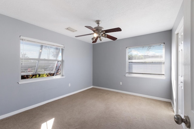 unfurnished room with ceiling fan, carpet, and a textured ceiling