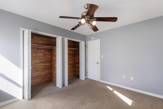 unfurnished bedroom with ceiling fan, light carpet, and wooden walls