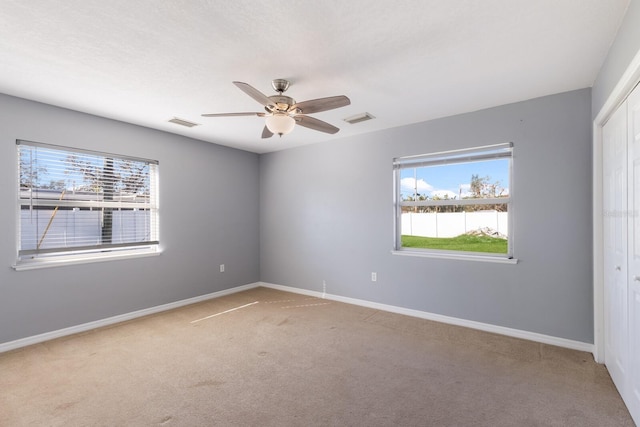 spare room featuring ceiling fan and carpet floors