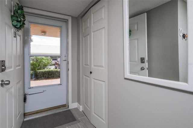 4550 Pinebrook Cir Unit 103, Bradenton, FL 34209 - doorway featuring baseboards and a textured ceiling