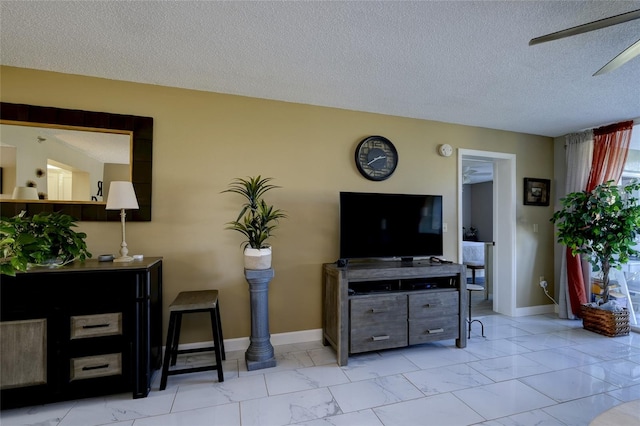 living room with ceiling fan and a textured ceiling