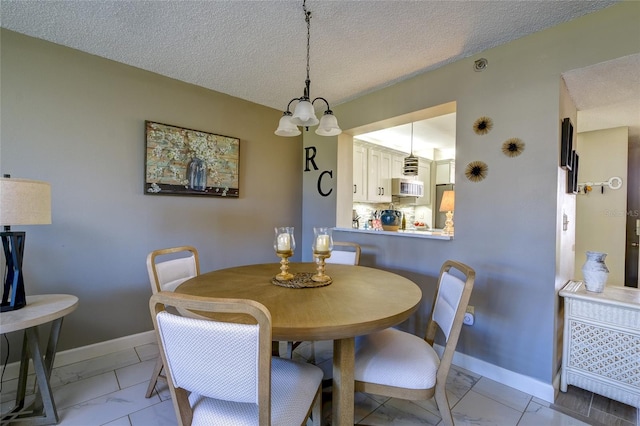 dining area featuring a textured ceiling and an inviting chandelier