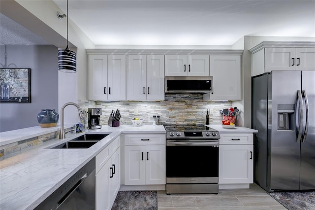 kitchen with decorative light fixtures, white cabinets, stainless steel appliances, and sink