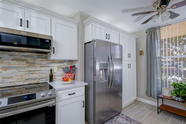 kitchen featuring appliances with stainless steel finishes, light wood-type flooring, ceiling fan, white cabinets, and decorative backsplash