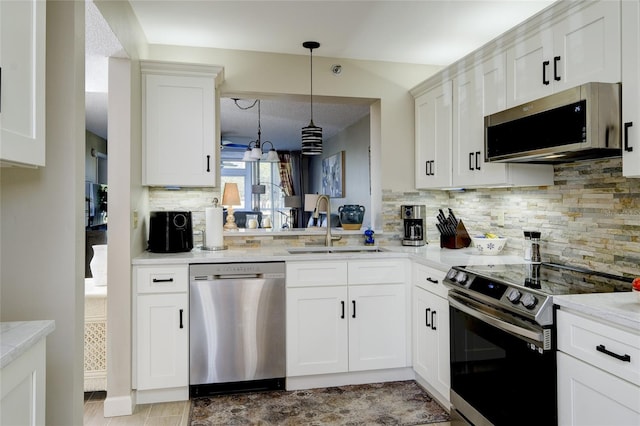 kitchen with white cabinetry, tasteful backsplash, appliances with stainless steel finishes, and hanging light fixtures