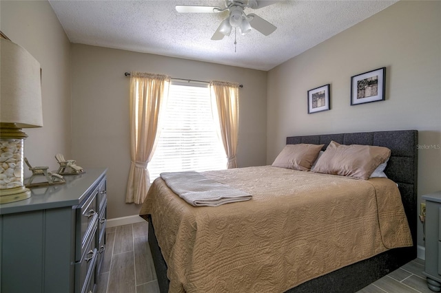 bedroom featuring dark wood-type flooring, ceiling fan, and a textured ceiling