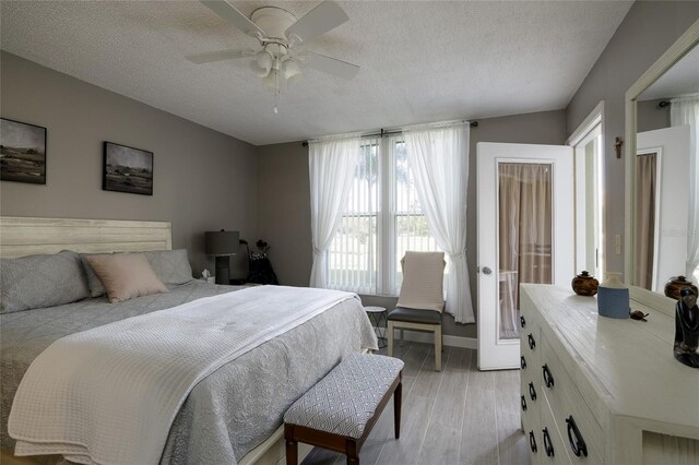 4550 Pinebrook Cir Unit 103, Bradenton, FL 34209 - bedroom with light wood-style floors, a textured ceiling, ceiling fan, and baseboards