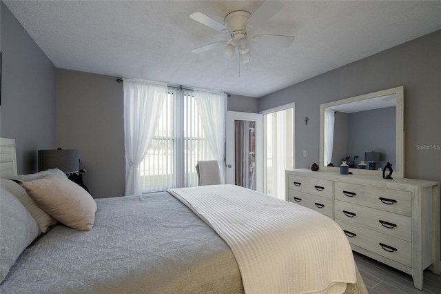 bedroom featuring ceiling fan, wood-type flooring, and a textured ceiling