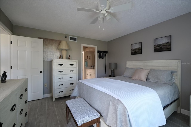 bedroom with dark hardwood / wood-style floors, ensuite bath, a textured ceiling, and ceiling fan