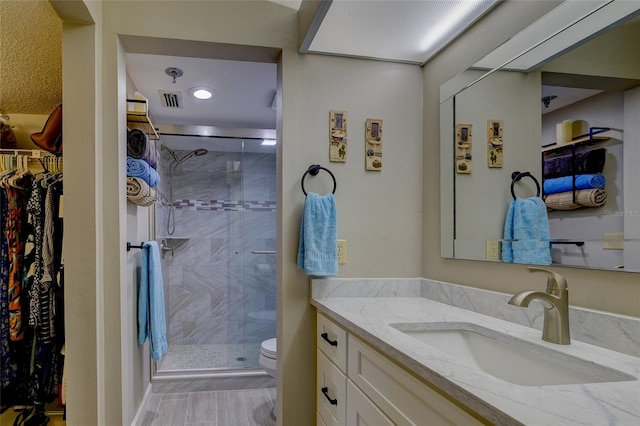 bathroom featuring vanity, toilet, and walk in shower