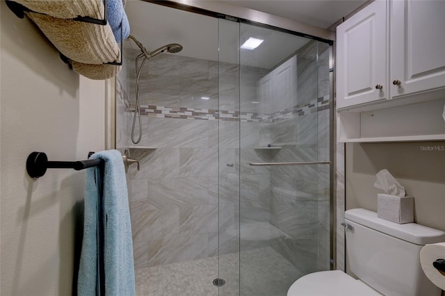 bathroom featuring toilet and an enclosed shower