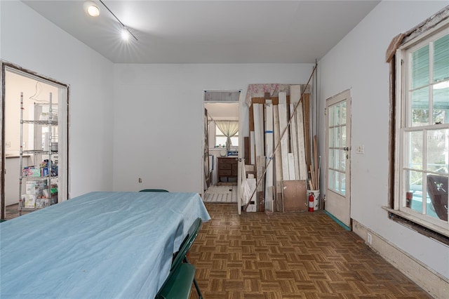 bedroom featuring dark parquet floors and multiple windows