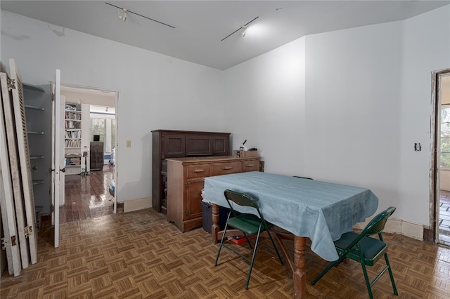 bedroom featuring track lighting and dark parquet flooring