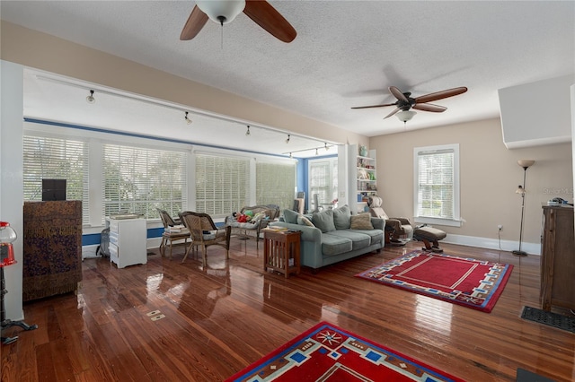 living room featuring dark hardwood / wood-style flooring, a textured ceiling, ceiling fan, and rail lighting