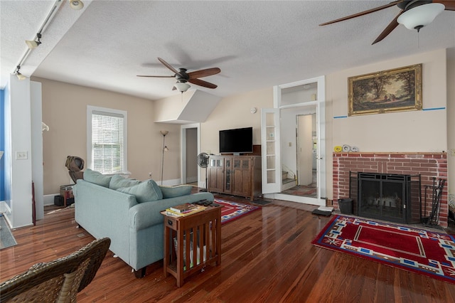 living room with a textured ceiling and dark hardwood / wood-style floors