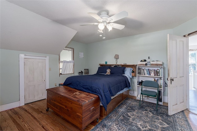 bedroom featuring dark wood-type flooring, ceiling fan, and multiple windows