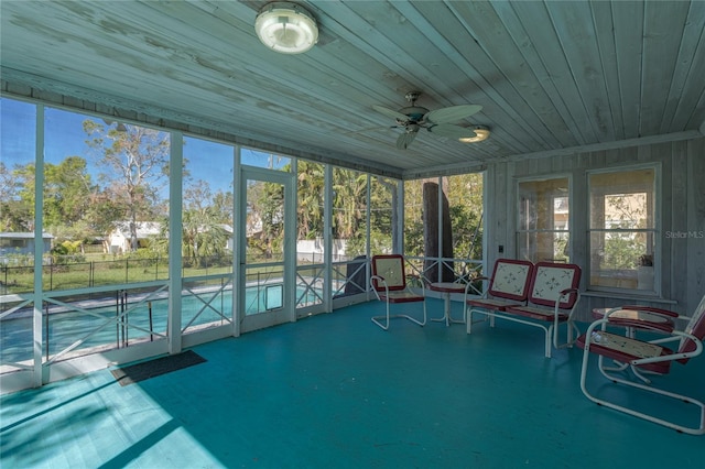 unfurnished sunroom with wood ceiling and ceiling fan