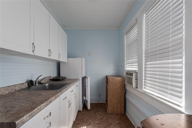 kitchen featuring ornamental molding, light parquet flooring, white cabinets, and sink