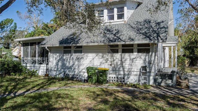 view of side of home with a lawn and a sunroom