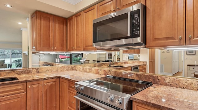 kitchen featuring ornamental molding, sink, light stone countertops, and stainless steel appliances