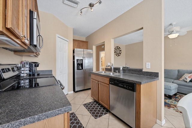 kitchen with stainless steel appliances, sink, light tile patterned floors, a textured ceiling, and ceiling fan