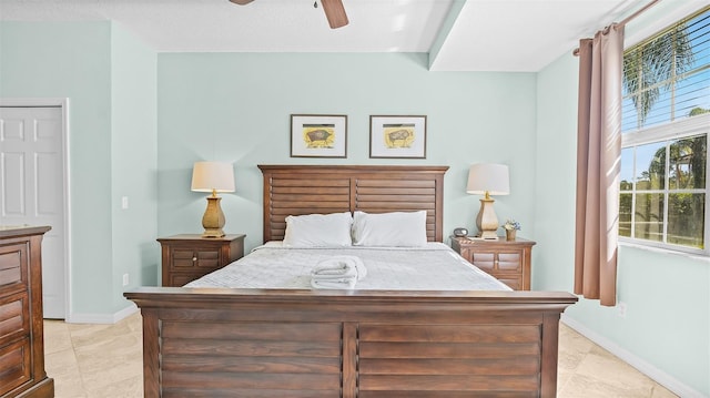 bedroom with a textured ceiling, light tile patterned flooring, and ceiling fan