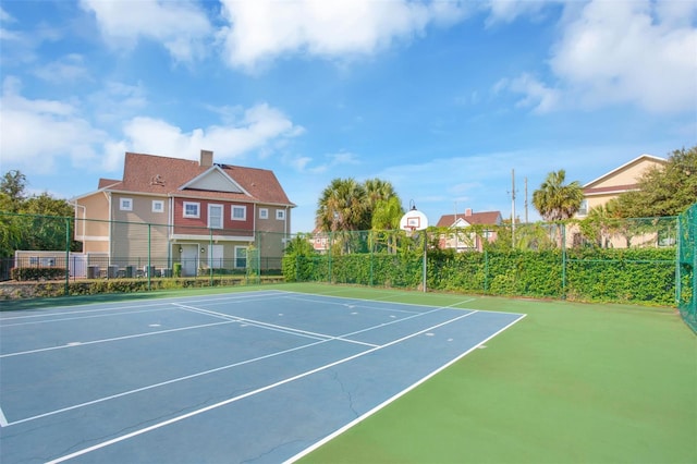 view of tennis court with basketball hoop