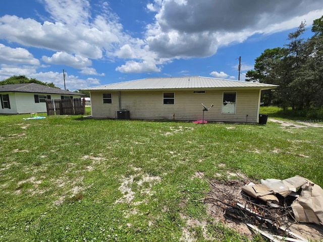 rear view of house with a lawn and central AC unit