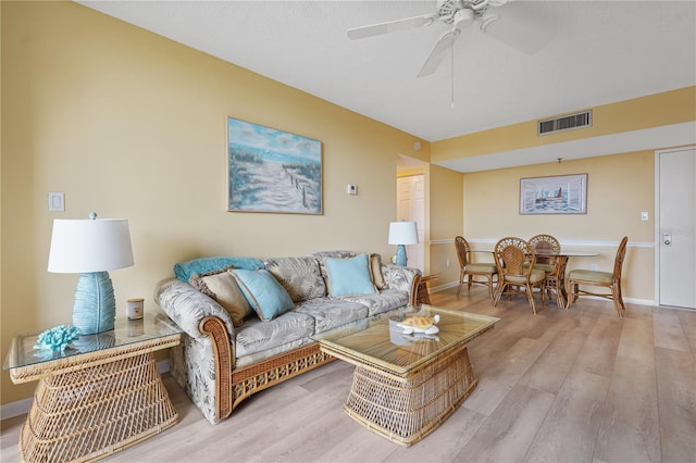 living room with ceiling fan and light hardwood / wood-style flooring