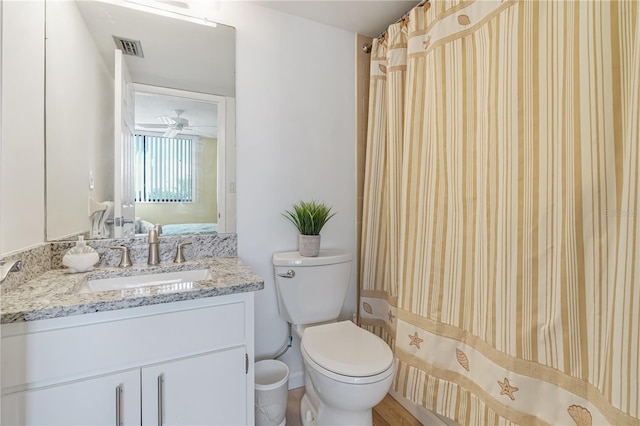 bathroom featuring ceiling fan, vanity, a shower with shower curtain, and toilet