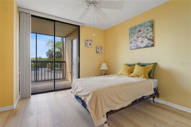 bedroom with ceiling fan, floor to ceiling windows, access to exterior, and light hardwood / wood-style flooring