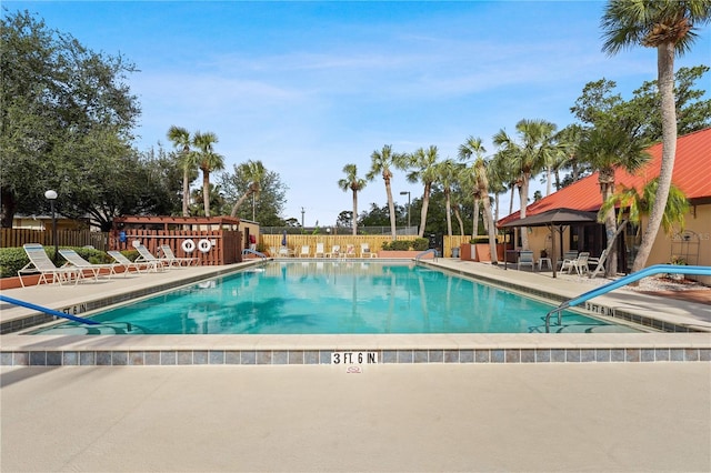 community pool with fence and a patio