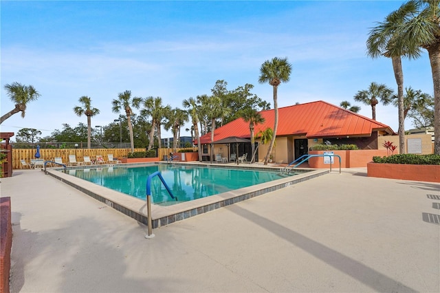 community pool featuring a patio area and fence