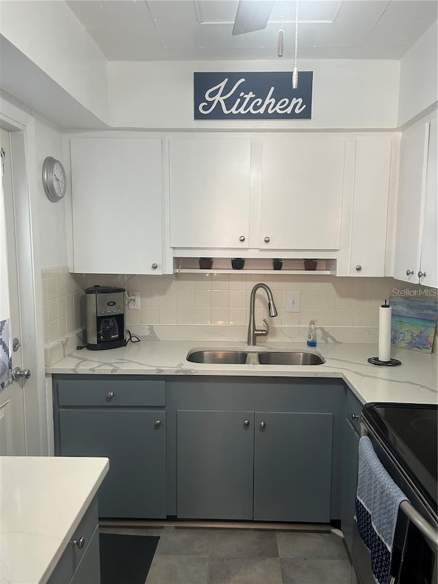 kitchen featuring sink, white cabinetry, gray cabinetry, and tasteful backsplash