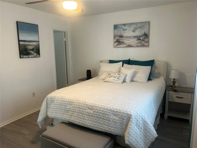 bedroom with baseboards, a ceiling fan, and dark wood-style flooring