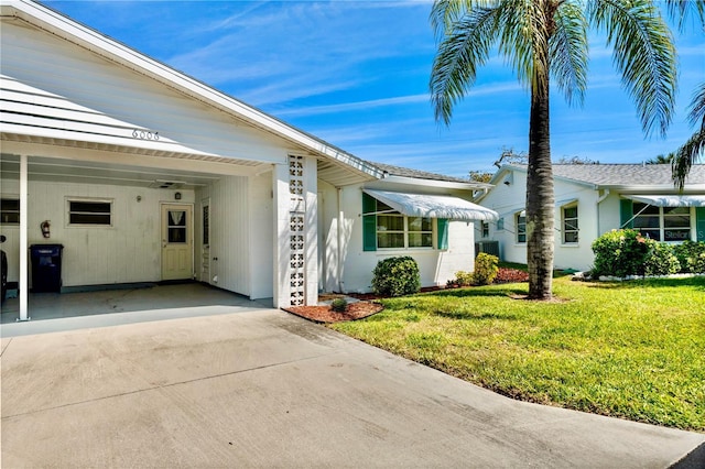 view of property exterior with concrete driveway and a yard