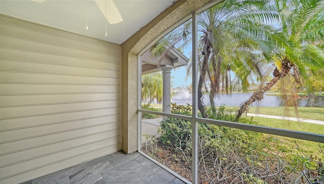 unfurnished sunroom featuring a water view