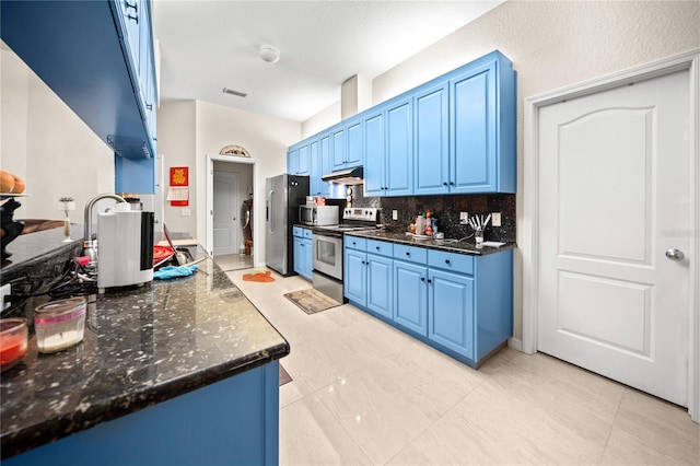 kitchen featuring appliances with stainless steel finishes, dark stone countertops, blue cabinets, and backsplash