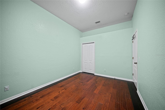 empty room featuring hardwood / wood-style flooring and a textured ceiling